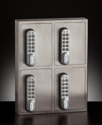 Ein Edelstahlfarbener Schlüsselsafe mit elektronischen Zahlenschloss und vier Schließfächern im geschlossenen Zustand